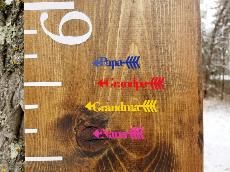 A Little Prairie Craft Co. wooden growth chart with arrows on it.