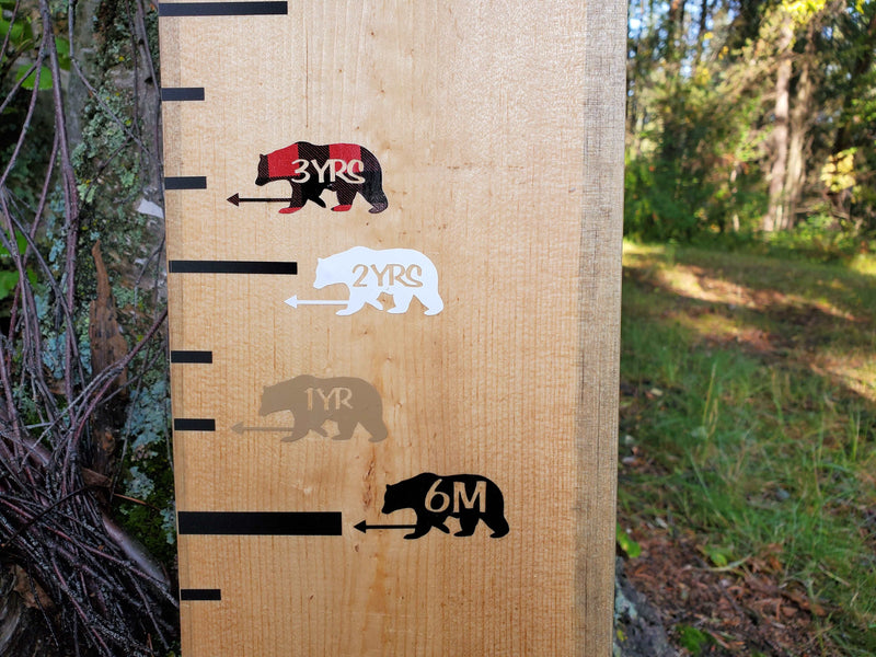 A wooden growth chart with Little Prairie Craft Co.'s Bear Height Marking Arrows on it.