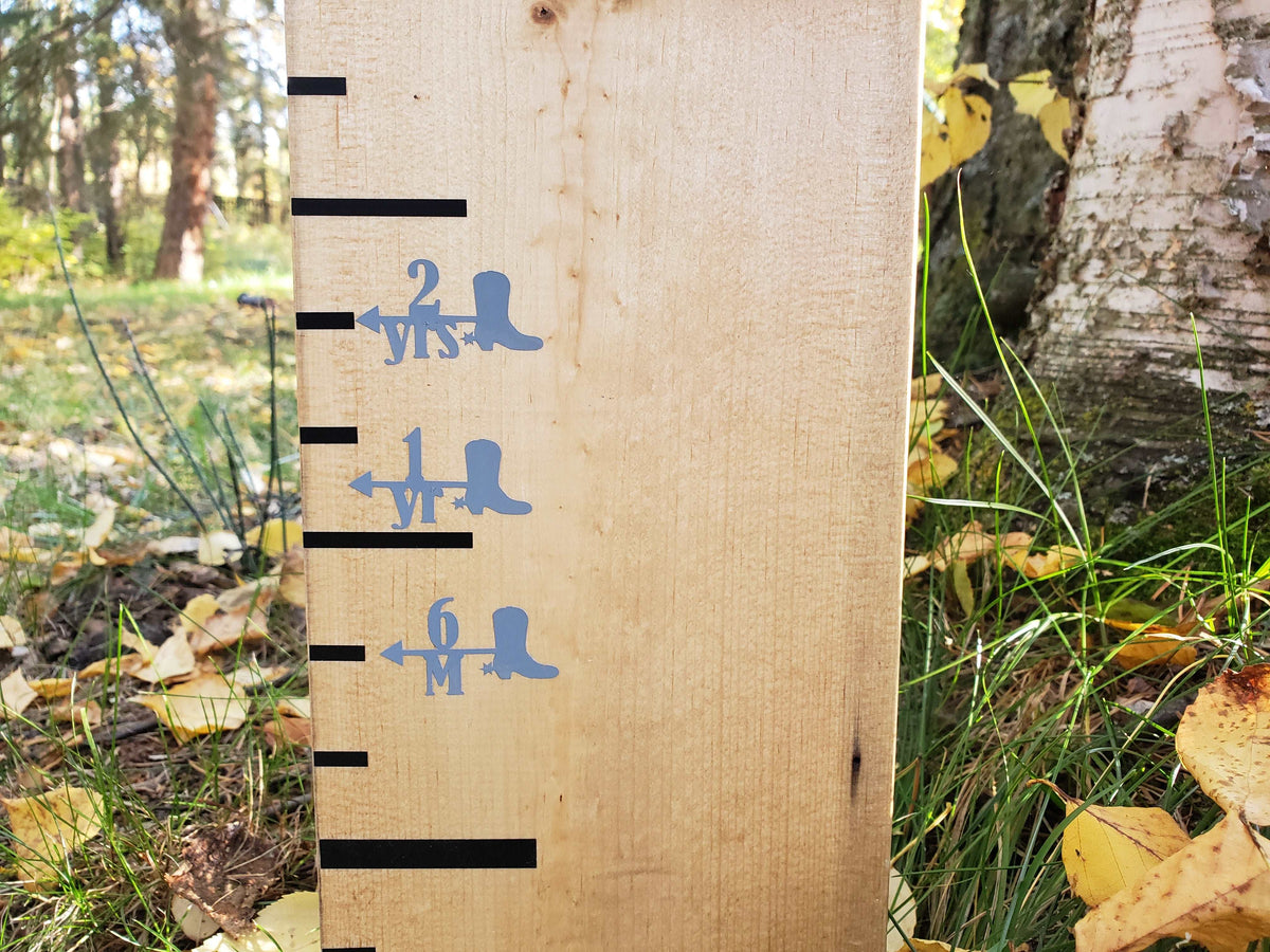 A Cowboy Boot Height Marking Arrows by Little Prairie Craft Co. growth chart in the woods.