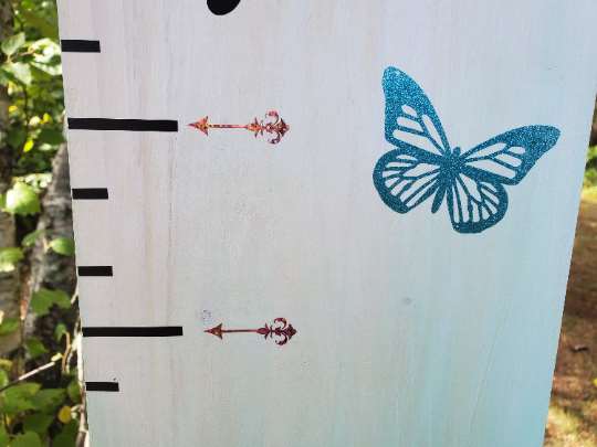 A Little Prairie Craft Co. wooden growth chart with a butterfly on it.