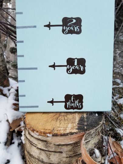 A wooden board with Magnolia Bubble Height Marking Arrows and Little Prairie Craft Co. ruler on it.