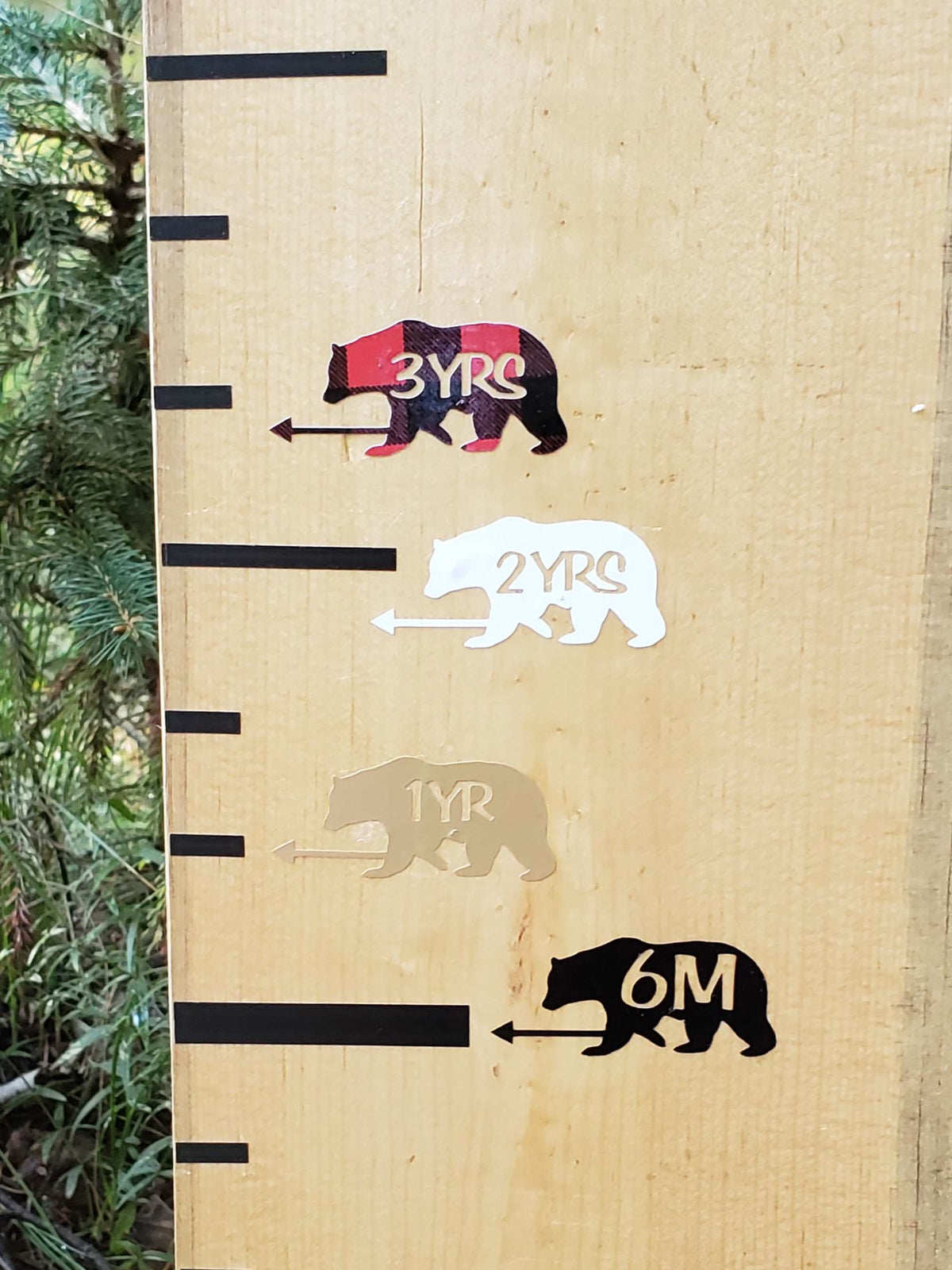 A wooden ruler with Bear Height Marking Arrows and Little Prairie Craft Co. branding on it.
