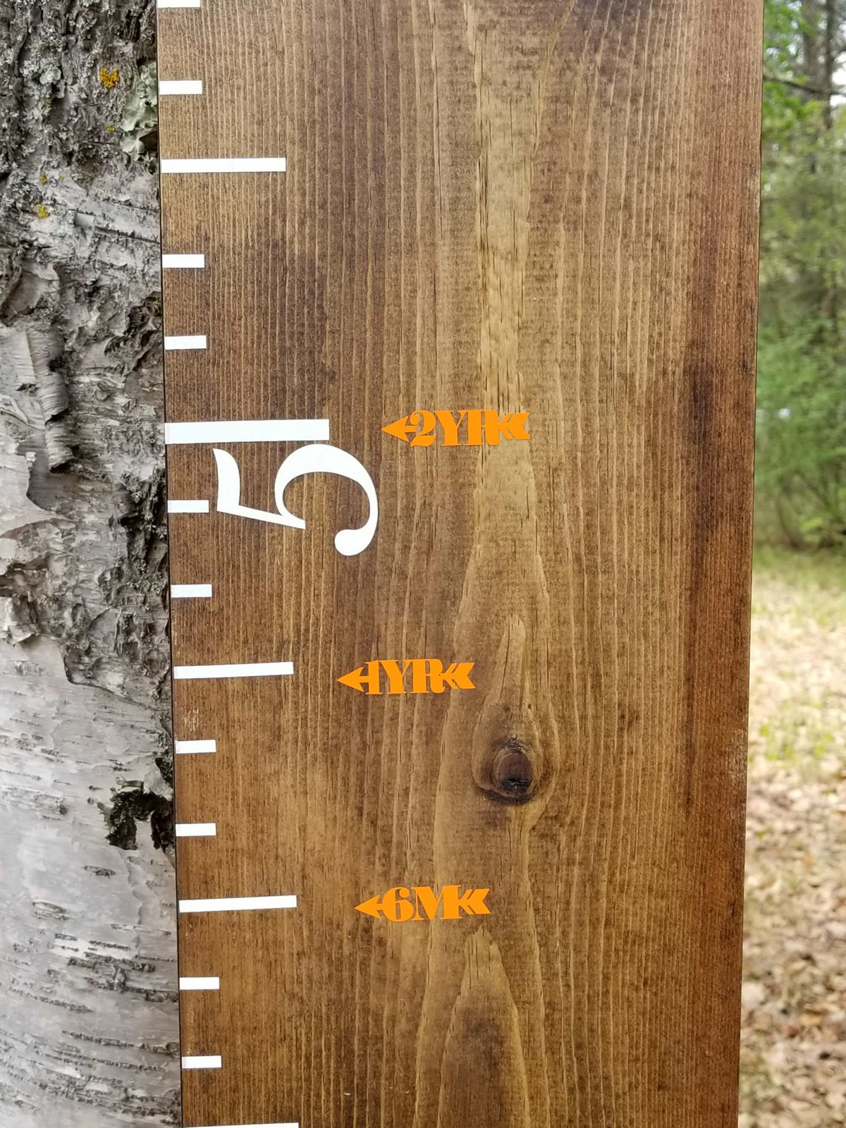 A Chunky Skinny Height Marking Arrows growth chart with orange numbers on it by Little Prairie Craft Co.