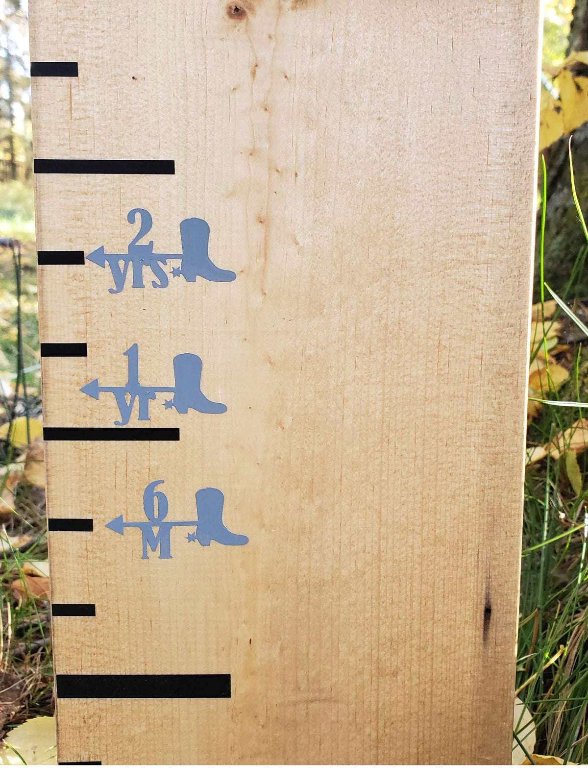 A Little Prairie Craft Co. wooden ruler with Cowboy Boot Height Marking Arrows on it.