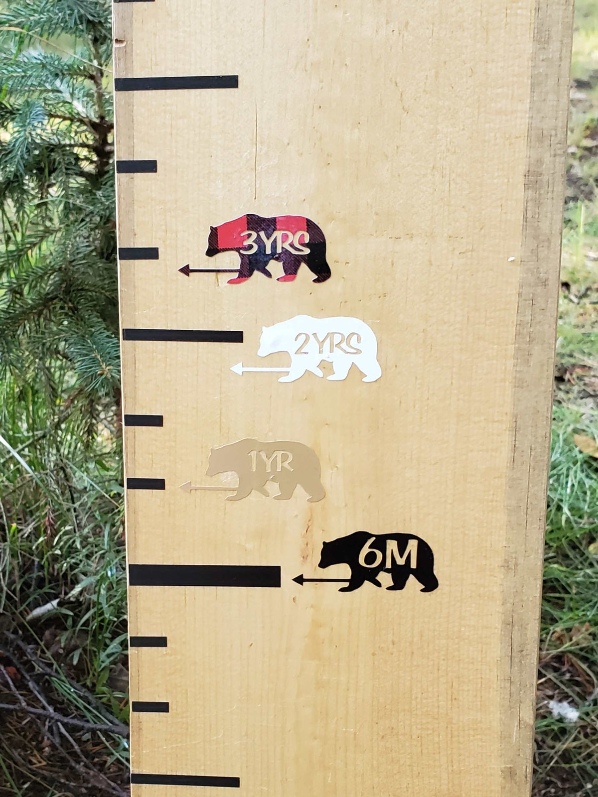 A wooden growth chart with Little Prairie Craft Co. Bear Height Marking Arrows on it.