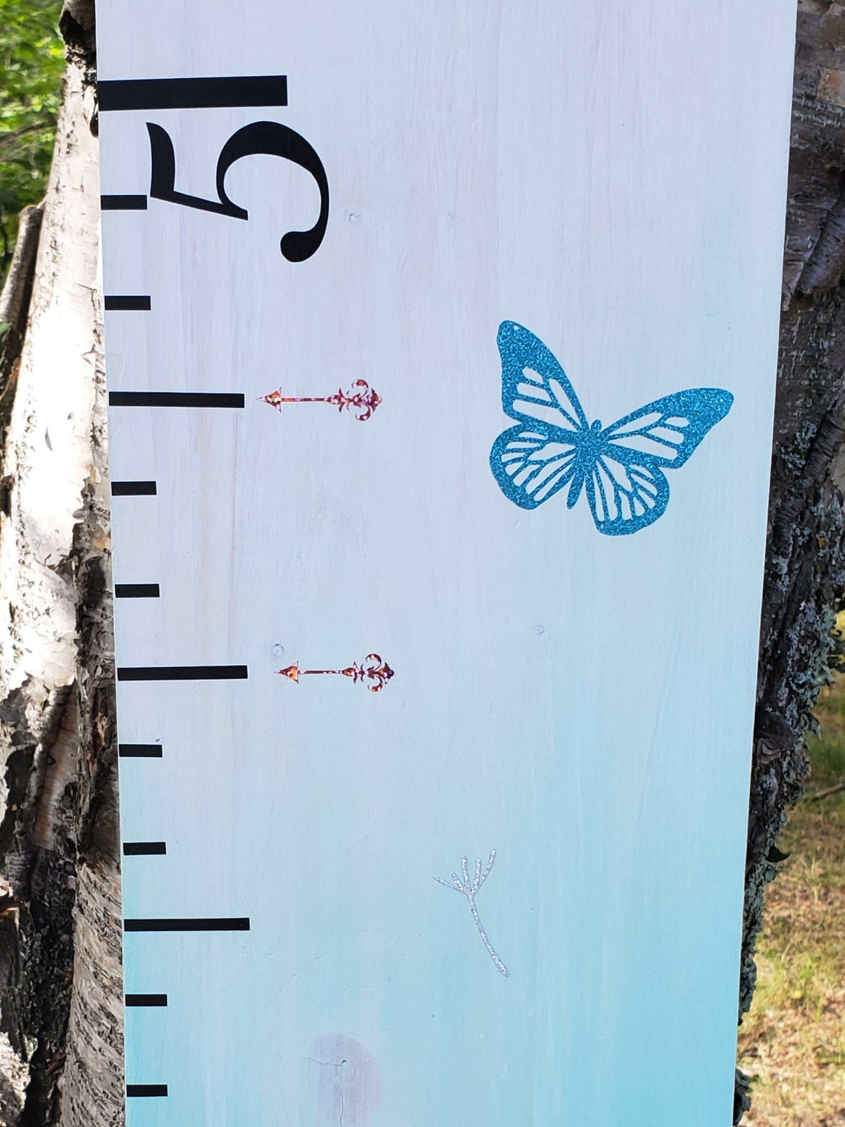 A Damask Height Marking Arrows growth chart with a butterfly on it by Little Prairie Craft Co.