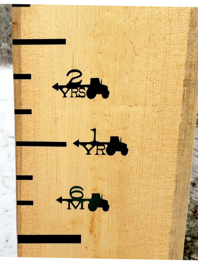 A wooden Tractor Height Marking Arrows growth chart with a tractor on it by Little Prairie Craft Co.
