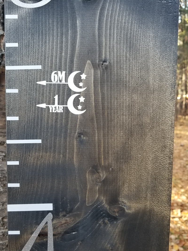 A Little Prairie Craft Co. Stars & the Moon Height Marking Arrows wooden ruler with a number on it.