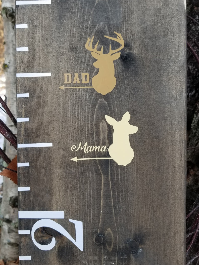A wooden growth chart with two Little Prairie Craft Co. Doe/Buck Parent Height Markers on it.