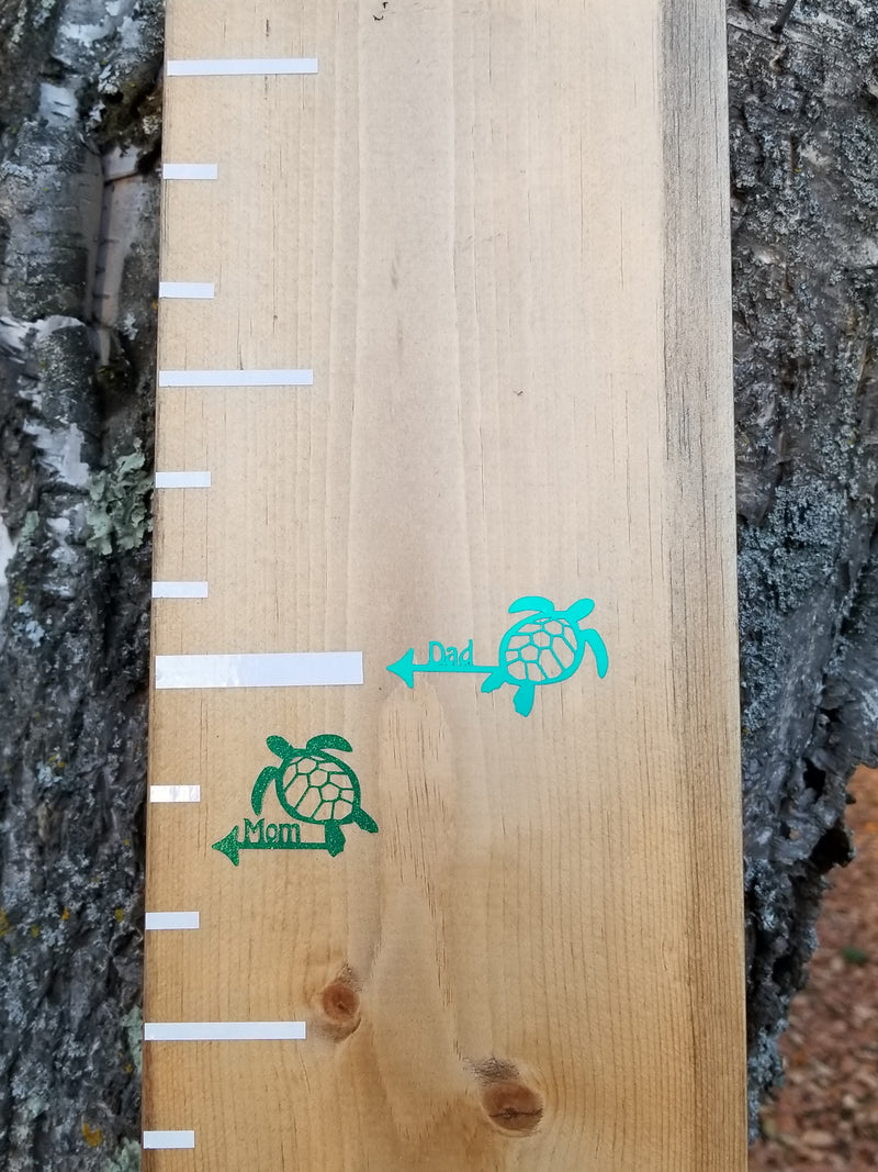 A wooden growth chart with Turtle Parent Height Markers from Little Prairie Craft Co. on it.