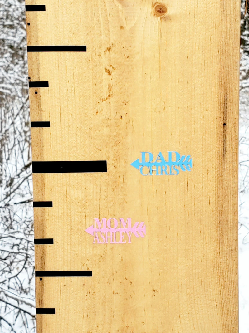 A Little Prairie Craft Co. wooden growth chart with arrows on it.